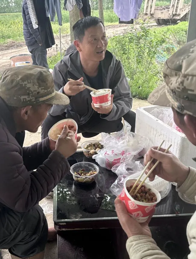 张海晖与师傅们围坐在一起吃盒饭。记者张衡 摄